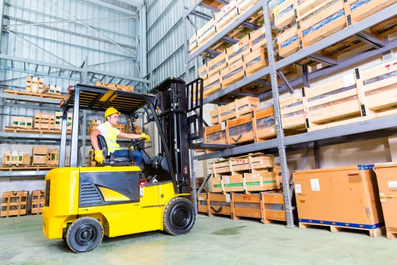 Wózek widłowy podnośnikowy podczas pracy na magazynie - https://new.get-a-truck.pl/